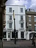 Column-mounted Richardson candle outside Gonville and Caius College, and wall-mounted behind