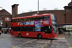 A red bus driving through Europe with a screen that shows Mario
