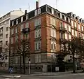 Brick building on a street corner with six stories
