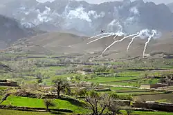 An AH-64 Apache helicopter shoots flares over a valley to support members of the 8th Commando Kandak and coalition special operations forces during a firefight near Nawa Garay village, Kajran district, Daykundi Province, Afghanistan.