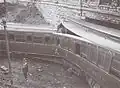 Wrecked coaches against the bridge.