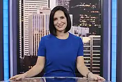 Amanda Lang pictured at a desk wearing a blue top