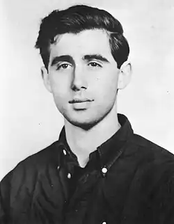 Black-and-white head shot of Goodman wearing a dark shirt