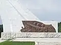 Bronze relief at base showing the Korean people