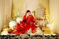 Photograph of a woman wearing a red Jamdani sari