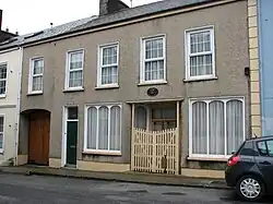 Photograph of a modest two-story house.