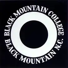 Three black and white concentric circles with the name of the college in white spelled around the final black circle