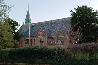 Victorian school with brick walls, tiled roof, and octagonal turret