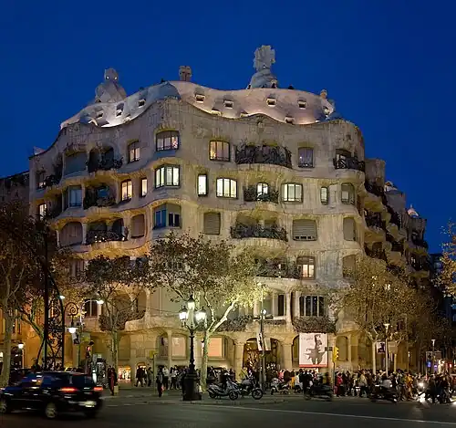 Image 20 Casa Milà Photo credit: David Iliff The Casa Milà, a 1912 work by Catalán architect Antoni Gaudi, in the Eixample district of Barcelona, Spain. Gaudí's fascination with trencadís-influenced decoration and curves (predating biomorphism by almost 20 years) can be seen here. More selected pictures