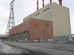 Picture of the generating station taken from route 132. A tall building with an even taller electric pylon on the right.