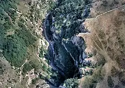 Jagged dark blue area of the gorge running form the bottom left to top right, surrounded by brown and green higher areas of land