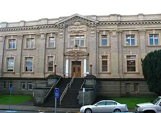 Photograph of a large two-story building with exposed basement