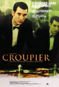 A man in a suit and bow-tie leaning over a roulette wheel