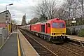 A DB Schenker Class 60 passes through the station with a freight train.