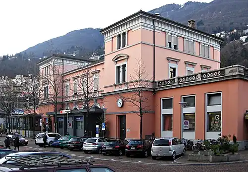 Stone building with two three-story towers with hipped roofs and single story wings