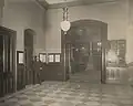 Male employee posing for the camera in an empty hallway. Directory on the wall next to him