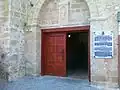 The stone plaque at the entrance to the church gives information in four languages