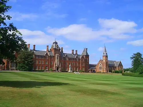broad neo-gothic building and chapel with manicured grounds
