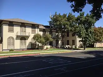 Tope two-story building with dark wood trim and a recessed front entrance