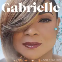 A close-up photo of the artist's face staring directly into the camera while her right eye is covered with her hair.