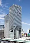 Ground-level view of a glass, rectangular high-rise