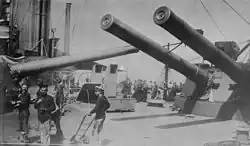 The crowded midships area of HMS&nbsp;Indomitable dominated by the masses of the 12-inch guns of 'P' and 'Q' turrets, each of which is trained across the deck