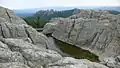 A man-made dam is located near the summit.