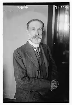 middle-aged white man, with neat hair and trimmed beard and moustache