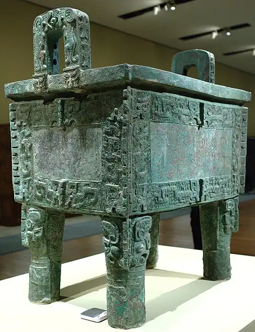 Rectangular bronze vessel with 4 legs and decorative motifs