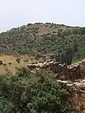 Deserted house in Farradiyya, with the hilltop ruin of Khirbet Abu esh-Sheba seen in distance