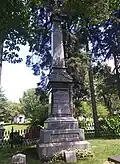 Tall and slender rectangular pillar atop of a rectangular base engraved with names