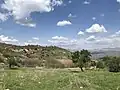 Kovli village nestled among green hills and distant mountains