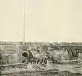 photo of fort yard with dirt-covered timbers leaned against interior walls and ditches cutting across