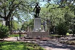 Bronze statue of a standing man in a tricornered hat holding a sword