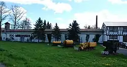 Four pieces of historic narrow gauge rolling stock from 1910-1970 displayed in front of the head quarters