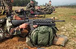 A U.S. Marine takes aim with an M16A2 fitted with the M203 40&nbsp;mm grenade launcher.
