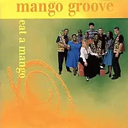 The album cover has a green, orange, and yellow colour scheme. The band's name is in orange serif type along the top of the cover. The album title is in yellow serif type, and runs vertically on the left side of the cover. Opposite the album title is a group photo of the band with their instruments.