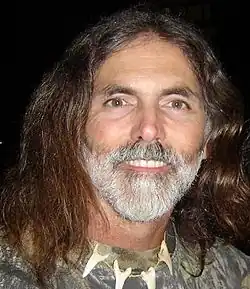 Manny Puig, American wildlife expert and television personality, known for his work with dangerous animals, wearing outdoor gear and smiling during a public event.