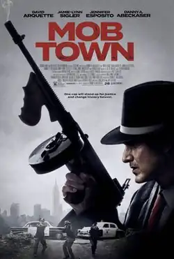 A man in a fedora looking over his shoulder and holding a tommy-gun as three police officers approach in the background.