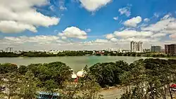 A lake as viewed from a tall building. The lake is in a populated area with a road.