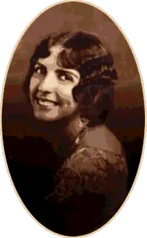 A studio photograph of a young woman looking over her shoulder.