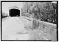 View of wall, built in 1914 after flood damaged original walls, and Southeast portal.