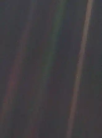 Image 13 Pale Blue Dot Photo credit: NASA/JPL Pale Blue Dot is the name given to this 1990 photo of Earth taken from Voyager 1 when its vantage point reached the edge of the Solar System, a distance of roughly 3.7 billion miles (6 billion kilometres). Earth can be seen as a blueish-white speck approximately halfway down the brown band to the right. The light band over Earth is an artifact of sunlight scattering in the camera's lens, resulting from the small angle between Earth and the Sun. Carl Sagan came up with the idea of turning the spacecraft around to take a composite image of the Solar System. Six years later, he reflected, "All of human history has happened on that tiny pixel, which is our only home." More selected pictures