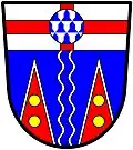 Yukon Territory (Canada): Azure, on a pallet wavy argent a like pallet azure, issuant from the base, two piles reversed gules, edged [=fimbriated] argent, each charged with two bezants in pale; on a chief argent, a cross gules, surmounted of a roundel vair.