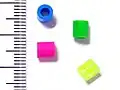 Typical fuse beads against a millimetre scale