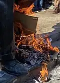 The feet of the statue, with fires set beneath it