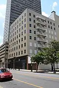 Ground-level view of an 8-story building with a tan brick facade.