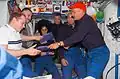 The STS-117 crewmembers give the station crewmembers packages