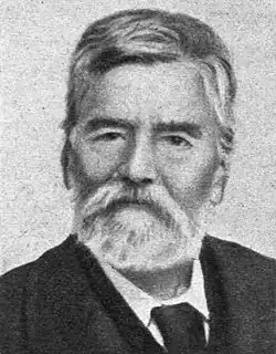 Black-and-white photograph of a bearded Greek man.