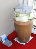 Suan cai preparation – a heavy stone is placed atop Chinese cabbages in a large pot. The cabbage will sink naturally in a few weeks as the fermentation begins. Salt, seen in the plastic bag in the lower left corner, is usually the only additive used.